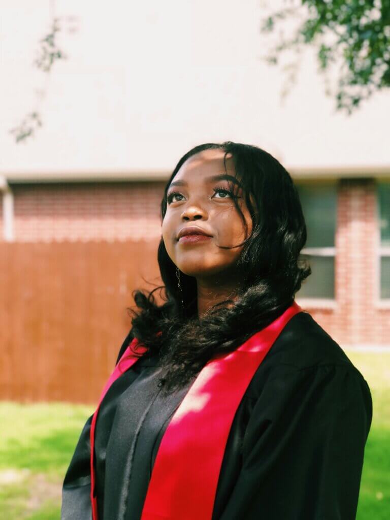 A female college graduate looks up at the sky