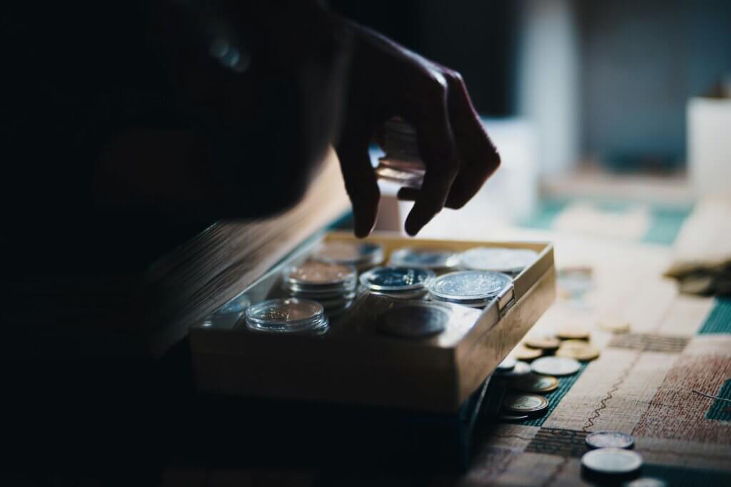 Close up of a hand putting coins into a box
