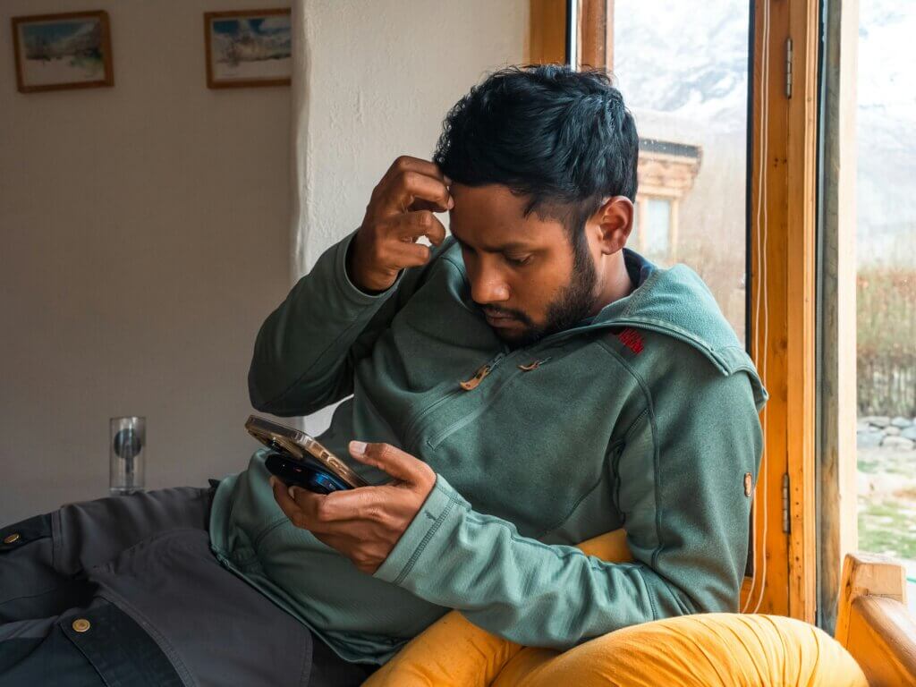 Man looks at his phone with a puzzled expression