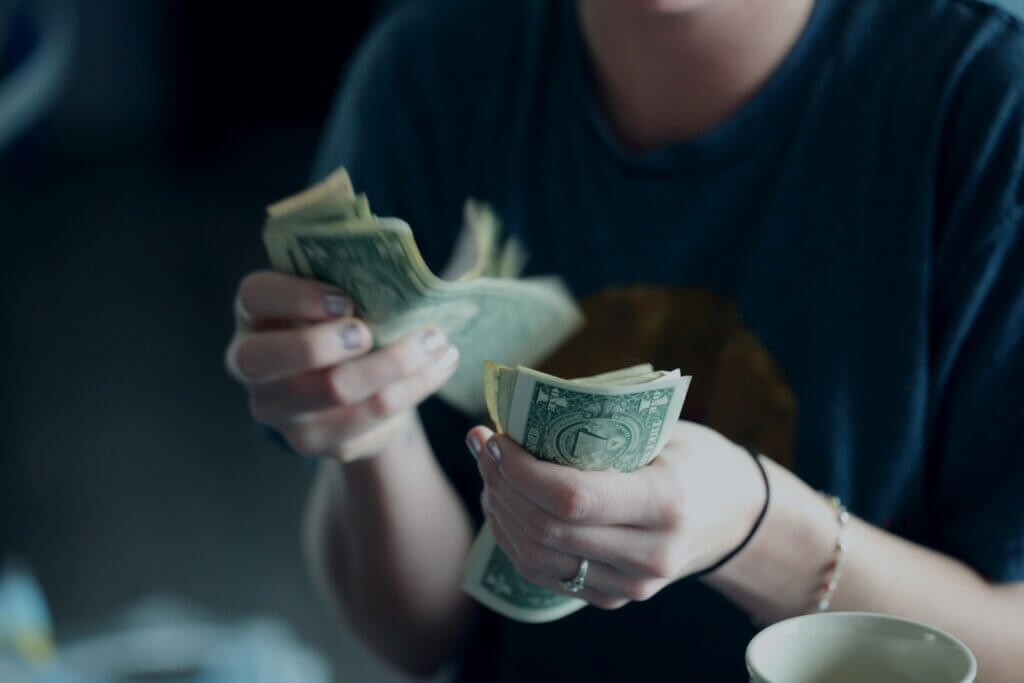 Close up of a person counting U.S. dollars.