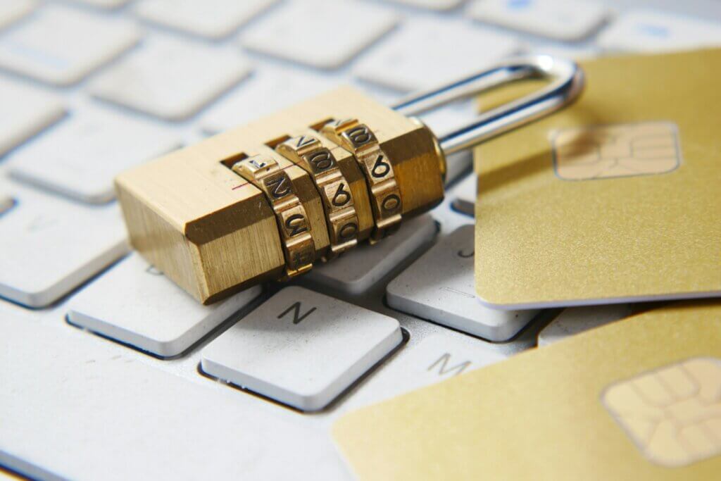 Golden padlock and bank cards sitting on top of a keyboard.